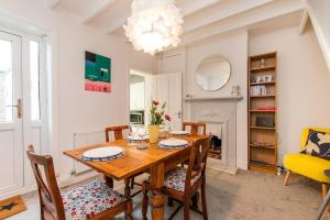 a dining room with a wooden table and chairs at Coal Miners Cottage - Moments To Seafront in Deal