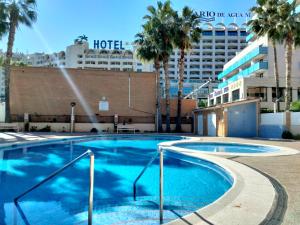 una grande piscina con un hotel sullo sfondo di ACV Bahia Park-1ª Línea Planta 5 Frontal Al Mar a Oropesa del Mar