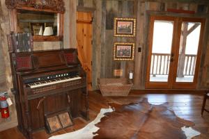 a living room with a piano and a mirror at Altamont Lodge in Newland