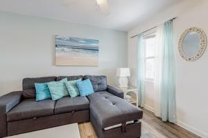 a living room with a gray couch and blue pillows at Sunrise Village #209 in Gulf Shores