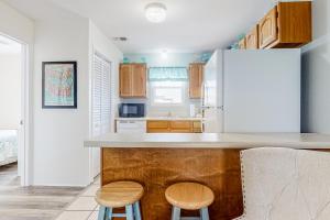 a kitchen with a white refrigerator and two stools at Sunrise Village #209 in Gulf Shores