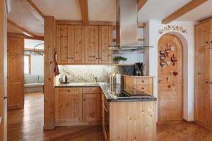 a kitchen with wooden cabinets and a counter top at BelaVal Apartments in La Villa