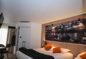昂熱的住宿－Logis Hôtel Angers Sud，酒店客房设有一张床,墙上挂有绘画作品