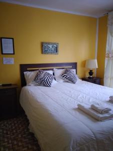 Un dormitorio con una gran cama blanca con dos almohadas. en hostal geminis ,phillipi 653 centro, en Puerto Natales