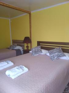 1 dormitorio con 2 camas y toallas. en hostal geminis ,phillipi 653 centro en Puerto Natales