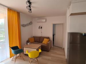 a living room with a couch and a table and chairs at EDA Beach Galerius Apartman in Siófok
