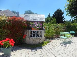 a garden with a table and chairs and flowers at Les 4 vents in Vineuil +12 photos