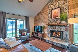 a living room with a stone wall with a fireplace at Modern Lake Geneva Home - 1 Mi to Boat Launch in Lake Geneva