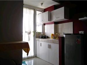 eine Küche mit einem Kühlschrank und einem Fenster in der Unterkunft Cozy corner in South Jakarta in Jakarta