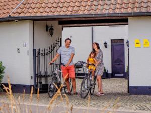een familie die voor een huis poseert met hun fietsen bij Het Hemelsveld in Hasselt