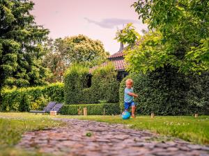 Un jeune garçon jouant avec un ballon dans une cour dans l'établissement Het Hemelsveld, à Hasselt