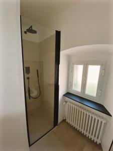 a bathroom with a shower and a window and a mirror at Appartamento Villa Cristina in Genoa