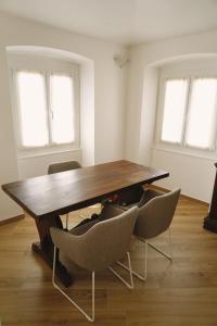 a wooden table and chairs in a room with windows at Appartamento Villa Cristina in Genova