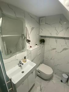 Mate Apartments في قشتيلا: حمام ابيض مع مرحاض ومغسلة