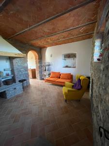 a living room with an orange couch and a yellow chair at Affittacamere Il Vecchio Mandorlo in Quarrata