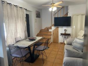 sala de estar con mesa, sillas y sofá en APARTAMENTO RURAL CASA MONTE en Cazalla de la Sierra