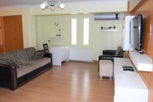 a living room with a couch and a tv at Dinara Hotel in Kemer