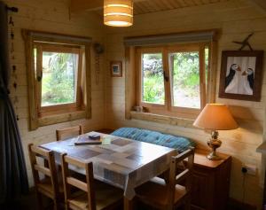 ein Esszimmer mit einem Tisch und 2 Fenstern in der Unterkunft Rodeen in Castletownbere
