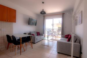 een woonkamer met een tafel en een bank bij Amelia Two Bedroom Apartment - 202 in Paphos City