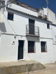a white building with windows and a door at APARTAMENTO RURAL CASA MONTE in Cazalla de la Sierra