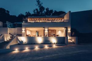 a house with lights on the front of it at night at Monastery Estate Guesthouse in Sougia