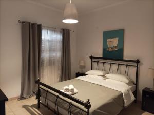 um quarto com uma cama com duas toalhas brancas em Villa Constantina Apartments em Liyiá