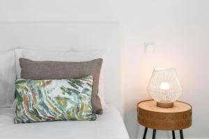 a bed with a pillow and a lamp on a table at Consolação Terrace in Consolacao