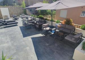 eine Terrasse mit Stühlen, Tischen und einem Sonnenschirm in der Unterkunft COCO in Veliko Gradište
