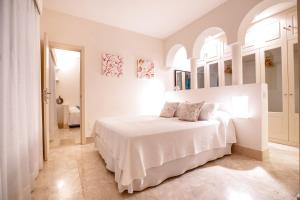 ein weißes Schlafzimmer mit einem weißen Bett in einem Zimmer in der Unterkunft Villa Bahía in Corralejo