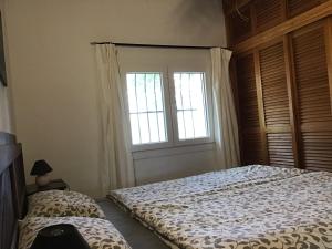 1 dormitorio con cama y ventana en El Estrecho, en Tarifa