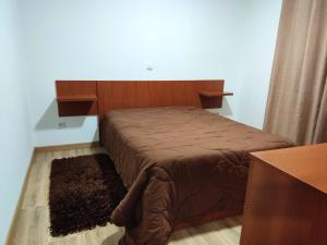 um quarto com uma cama com uma cabeceira de madeira em 2 bedrooms house with sea view enclosed garden and wifi at Marinhas em Marinhas