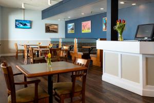 um restaurante com mesas e cadeiras e um bar em Rodd Grand Yarmouth em Yarmouth