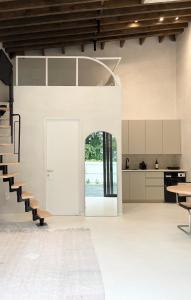 a living room with a staircase and a kitchen at Atelier Lumi at Lumicollection in Miami