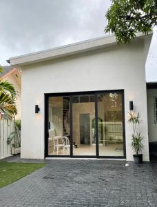 Biały dom z dużymi przesuwnymi szklanymi drzwiami w obiekcie Atelier Lumi at Lumicollection w Miami