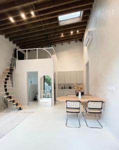 a room with a table and chairs and a staircase at Atelier Lumi at Lumicollection in Miami