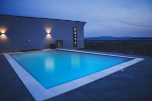 a swimming pool lit up at night on a rooftop at Villa Vajta in Dobrovo