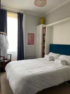 um quarto com uma grande cama branca e uma cabeceira azul em Traditional apt close to city centre & Hampden em Glasgow