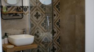 y baño con lavabo y ducha. en Palazzo Donna Chicchi, en Galatone