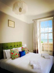 a bedroom with a large bed with a window at Chapter 1 Hotels in Weymouth