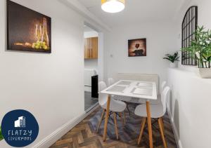 a dining room with a white table and chairs at FLATZY - Modern Apartment Close to Football Stadiums in Liverpool