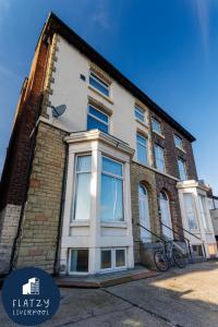 a building with a bike parked in front of it at FLATZY - Modern Apartment Close to Football Stadiums in Liverpool