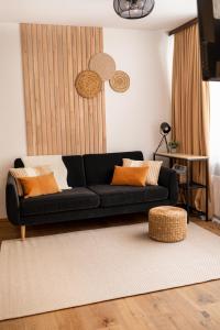 um sofá preto sentado numa sala de estar em Almara - 2 bedroom - 60 m2 - Family Apartment em Bad Goisern