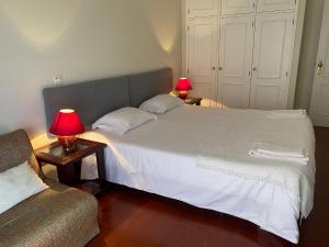 a bedroom with a bed with two lamps and a couch at Apartamento Ruy Belo - Foz in Vila do Conde