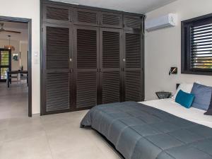 a bedroom with a large bed with wooden shutters at Zen Oceanfront Condo in Kralendijk +5 photos