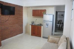 a kitchen with a brick wall and a white refrigerator at Departamento con buena ubicación in Corrientes +3 photos