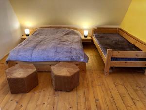 a bedroom with two beds and two stools in it at Chalupa Sunny Cottage in Svoboda nad Úpou