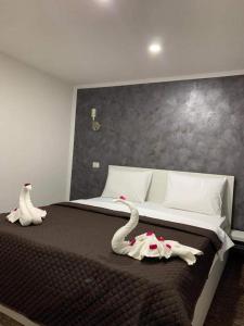 a bedroom with a bed with swans on it at La Zinculescu in Albeştii Pămînteni