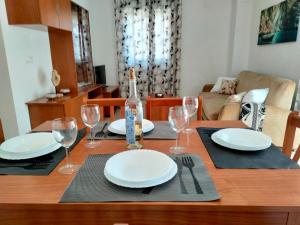 uma mesa com pratos e copos e uma garrafa de vinho em ACV - Costa Caribe II-2ª linea, planta 6, frontal em Oropesa del Mar