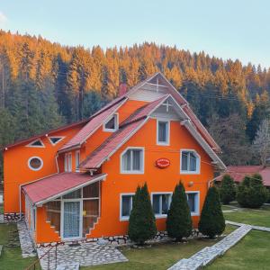 una casa de naranjos con árboles en el fondo en Pensiunea Marydor, en Gârda de Sus