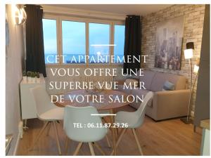 a living room with two chairs and a sign at residence du bord de mer 9 appartements avec une vraie vue mer in Le Tréport